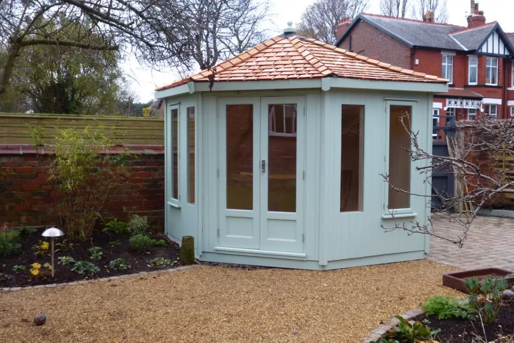 THIS IS A VAULTED ROOF CORNER SUMMERHOUSE WITH A CEDAR ROOF, FULLY LINED AND INSULATED WITH ELECTRICS